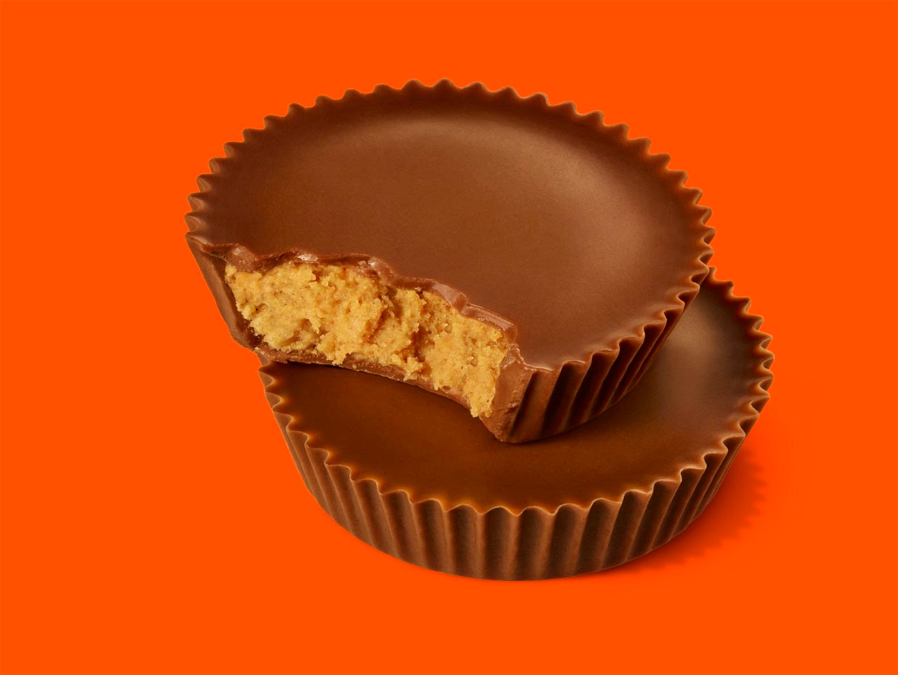 Dois REESE'S cup empilhados, um deles mostrando o interior do doce