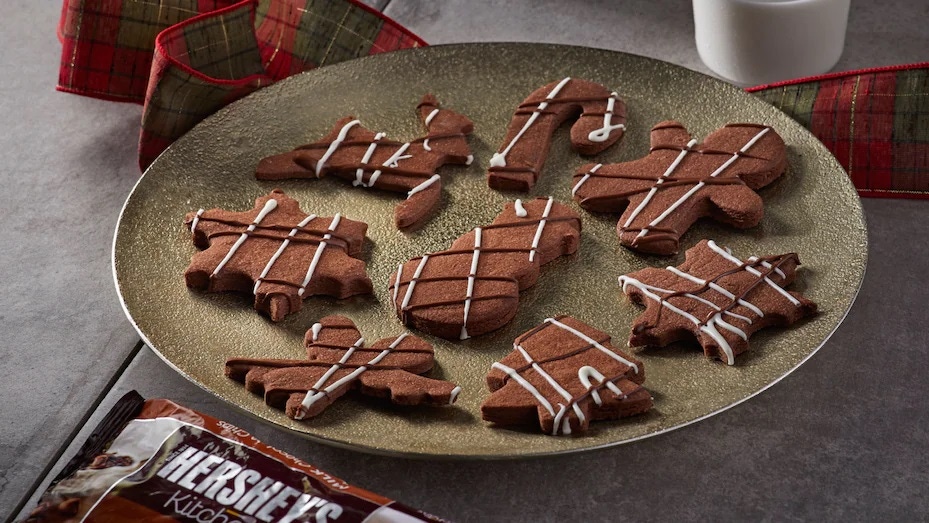 Oito biscoitos de natal, de diversos formatos, em um prato dourado.